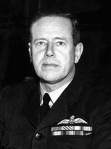 Head-and-shoulders portrait of man in dark military uniform with ribbons and pilot's wings on chest