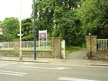 Photograph of an external wall and a gate at the boundary of Westow Park.