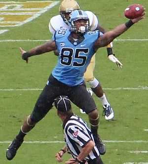 An American football player catching a football in mid-air.