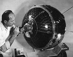 Scientist working on satellite using a tool on the presumed front of the craft