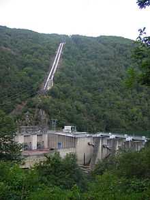 Power station next to a river dam, with two steel tubes bringing water from a unseen lake 500m above.