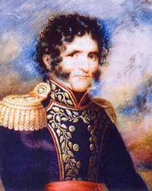 Head and shoulders of curly haired young man with bushy sideburns and moustache, dressed in 19th-century clothes.