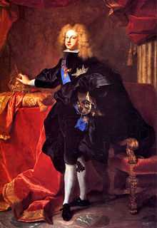 Standing man with light, curly hair, dressed in dark-colored royal finery