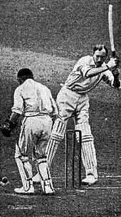 A cricketer trying to hit a ball watched by a wicketkeeper