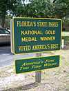 two green signs with yellow border and lettering about Florida State Parks
