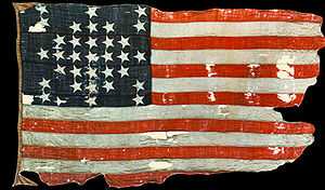 Photograph of a faded and torn United States flag