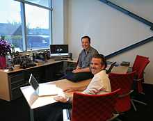 Picture of man seated in an office with another man across the desk from him