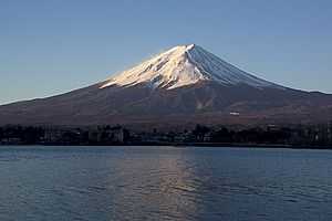 Perfectly shaped volcano with the upper half covered in snow.