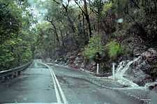 Water sluicing across Galston Gorge Road during rain