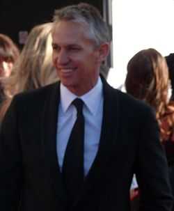 A man in a dark suit, white shirt and black tie