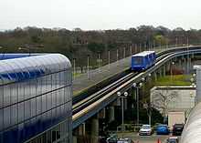 Blue, three-car train approaching a station