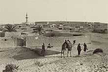 Walled town of El Arish, with camel and men in foreground
