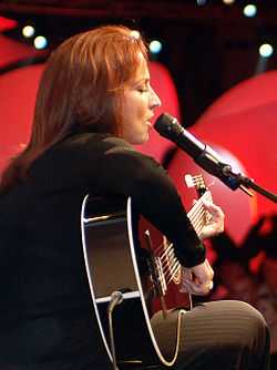 A woman playing the guitar.