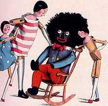 A drawing depicting  a rag doll with a big, black head, sitting in a rocking chair, with three white children standing by.