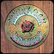 A woodgrain panel with a circle in the middle—inscribed is a rose surrounded by the words "American Beauty"