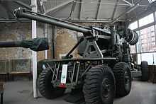 An anti-aircraft gun on a wheeled chassis. On the back of the long gun barrel are two large drums for holding ammunition. There is a small control booth on the right hand side of the vehicle.
