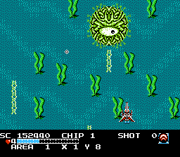 A red spaceship at the bottom of the picture, behind a blue background that resembles an ocean floor, dodges projectiles from the enemy boss, a round, green, amoeba-like creature, on the top of the picture.