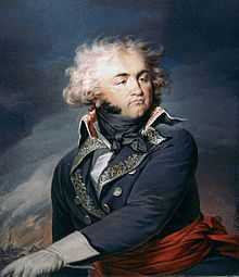 Painting of a man with a round face, cleft chin and wildly wavy hair. He wears a dark blue military uniform of the 1790s era.