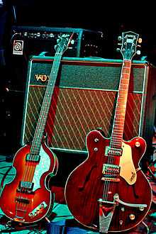 Two electric guitars displayed with an amplifier.