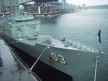 Photograph of a frigate's bow and the front of her superstructure. Two weapons systems can be seen on the forward deck.