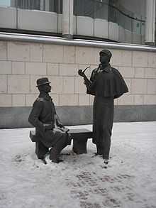 Sculpture of Holmes, standing holding his pipe, and Watson sitting on a bench