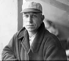 Black-and-white image of Hugh Duffy in a baseball cap and jacket, looking left