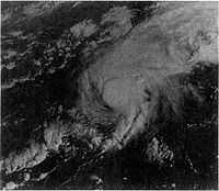 A satellite image of a hurricane. The storm has strong thunderstorm development around its small center and Bermuda is completely obscured by it