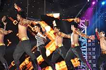Priyanka Chopra dancing on stage with a group of men