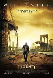 A man wearing leather clothes and holding a rifle walks alongside a dog on an empty street. A destroyed bridge is seen in the background. Atop the image is "Will Smith" and the tagline "The last man on Earth is not alone". Below is the film's title and credits.