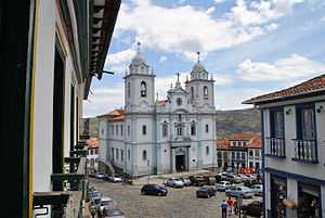 Old church, cobble stone streets and two-storied houses with white facades.