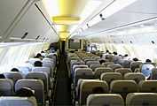 Cabin of the 767. There are seven seats per row, with two aisles separating the seats. Light shines through the side-wall windows and overhead lighting.