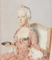  Solemn-faced girl child in a pink dress decorated with bows. Facing half-left, she carries an object in her right hand that might be a compact, or a mirror.