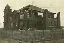 Old photo of a building that has part of its facade damaged.