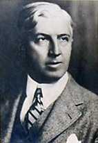 Bust of white-haired man wearing suit and tie