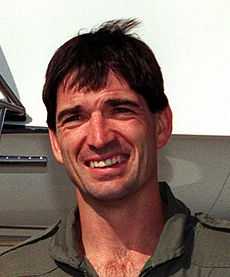 Head shot of a man, wearing a gray shirt