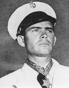 Black and white photo of male individual in chief petty officer dress whites wearing the Navy Medal of Honor