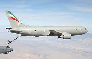 A mostly-gray KC-767, with refueling probe extended, transferring fuel to a B-52 in the left-bottom hand corner.