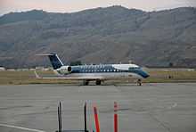 An aircraft located on a runway, with a mountain in the background.