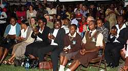 Audience seated in rows, smiling and clapping