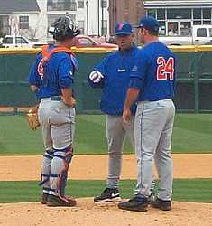 Photograph depicts Florida Gators baseball coach Kevin O'Sullivan having a pitcher's mound conference with Gators pitcher and catcher.