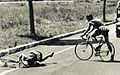 A cyclist laying in the road after an accident.