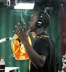 Kodjo Akolor from the side, speaking into a microphone as a host during Musikhjälpen 2011.