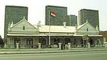 A Dutch colonial-style house with the flag of the South African Republic flying outside.