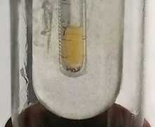 Small sample of pale yellow liquid fluorine condensed in liquid nitrogen