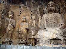 Carved Buddhist deities in a rock face.