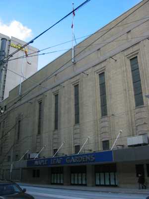 An exterior view of a building. The building has a sign that says "Maple Leaf Gardens" on the front.
