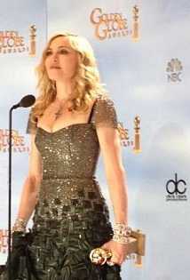  A blond woman standing in front of a microphone holding an award.