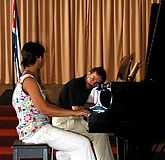 Kretzer watching a student play the piano