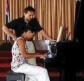 Kretzer watching a student play the piano