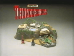 Scale, toy model of a tropical island, with stationary, futuristic air- and spacecraft and "Thunderbirds" title